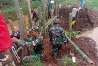 Anggota Koramil 12/Margorejo Pati, saat memperbaiki tanggul jebol sungai Silugonggo Jimbaran.