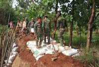 Anggota Koramil Tambakromo Pati berjibaku bersama warga perbaiki tanggul sungai yang retak. (Dok.Ist).