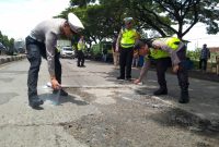 Foto: Personel Polres Demak, saat memberikan tanda cat jalan berlubang Jalan Pantura KM 31+200 Semarang-Kudus Desa Bolo Kecamatan Demak Kabupaten Demak. (Dok. Ist)
