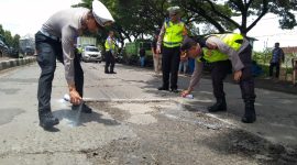 Foto: Personel Polres Demak, saat memberikan tanda cat jalan berlubang Jalan Pantura KM 31+200 Semarang-Kudus Desa Bolo Kecamatan Demak Kabupaten Demak. (Dok. Ist)