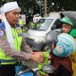 Foto: Petugas Polres Demak, saat membagikan takjil untuk pengguna jalan.