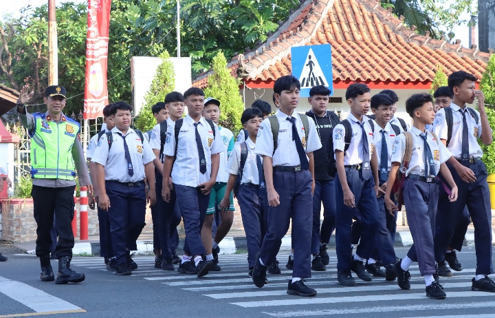 Petugas kepolisian Jepara, saat mendampingi pelajar menyeberangi jalan.