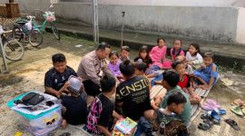 Bhabinkamtibmas Desa Geneng Kec. Mijen, Kab. Demak, saat bersama anak-anak baca buku perpustakaan keliling.