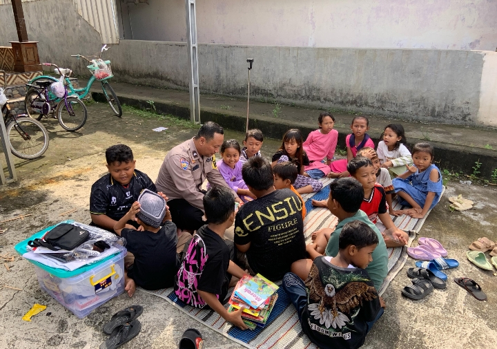 Bhabinkamtibmas Desa Geneng Kec. Mijen, Kab. Demak, saat bersama anak-anak baca buku perpustakaan keliling.