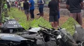 Motor korban nampak remuk, sementara warga berkumpul di lokasi kejadian.
