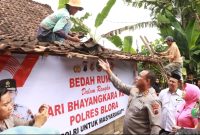 Kapolres Blora AKBP Wawan Andi Susanto turun langsung bantu tukang turunkan genteng.