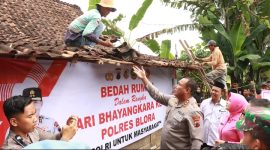 Kapolres Blora AKBP Wawan Andi Susanto turun langsung bantu tukang turunkan genteng.