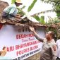 Kapolres Blora AKBP Wawan Andi Susanto turun langsung bantu tukang turunkan genteng.