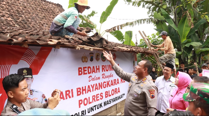Kapolres Blora AKBP Wawan Andi Susanto turun langsung bantu tukang turunkan genteng.