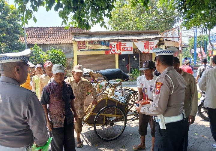 Petugas Polres Demak saat sosialisasi dengan pengayuh becak.