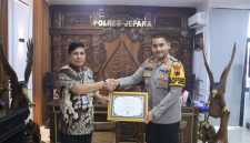 Kepala Kantor Pelayanan Perbendaharaan Negara (KPPN) Kudus Eko Wahyu Budi Utomo, saat memberikan piagam penghargaan kepada Kapolres Jepara AKBP Erick Budi Santoso di Mapolres Jepara, pada Jumat (18/7/2025).
