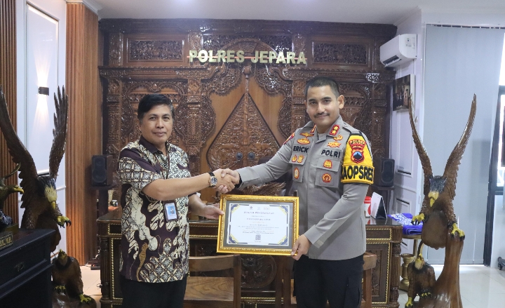 Kepala Kantor Pelayanan Perbendaharaan Negara (KPPN) Kudus Eko Wahyu Budi Utomo, saat memberikan piagam penghargaan kepada Kapolres Jepara AKBP Erick Budi Santoso di Mapolres Jepara, pada Jumat (18/7/2025).