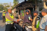 Anggota Satlantas Polres Jepara saat memberikan hadiah kepada pengendara yang tertib berlalu lintas.
