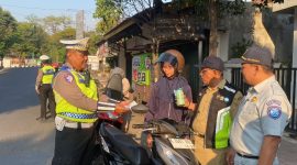 Anggota Satlantas Polres Jepara saat memberikan hadiah kepada pengendara yang tertib berlalu lintas.