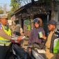 Anggota Satlantas Polres Jepara saat memberikan hadiah kepada pengendara yang tertib berlalu lintas.