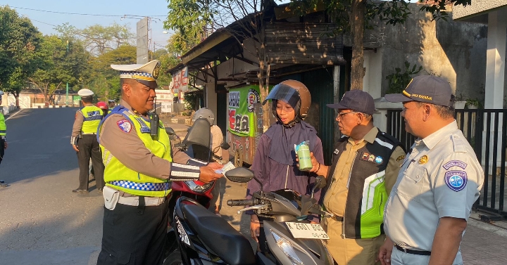 Anggota Satlantas Polres Jepara saat memberikan hadiah kepada pengendara yang tertib berlalu lintas.