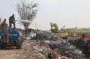 Prajurit Kodim Pati saat menyemprotkan cairan mikroba ke tumpukan sampah.
