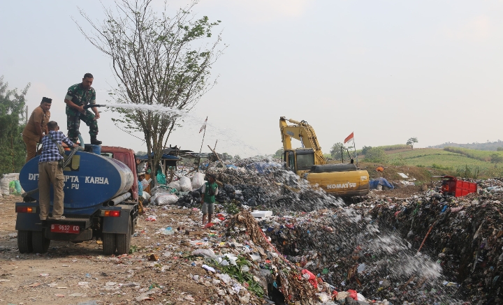 Prajurit Kodim Pati saat menyemprotkan cairan mikroba ke tumpukan sampah.