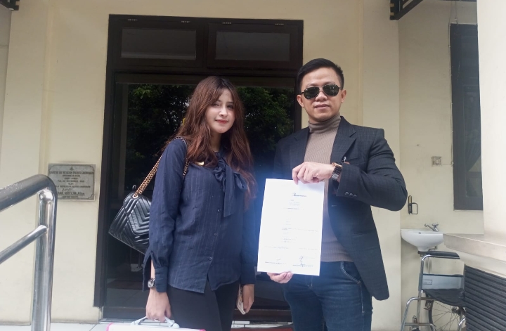 Dari kanan, Bagas Pamenang, SH, MH, didampingi asistennya, saat menunjukan bukti laporan aduan polisi. Kamis (30/10/2025).