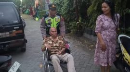 AKP Sugiman SH, saat mengantar seorang kakek pergi ke gereja, dengan mendorong kursi roda.
