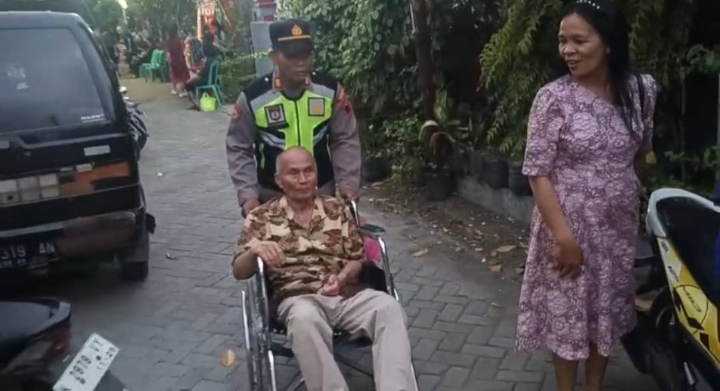 AKP Sugiman SH, saat mengantar seorang kakek pergi ke gereja, dengan mendorong kursi roda.