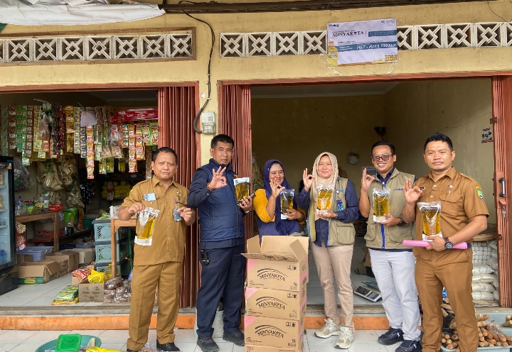 Tim Satgas Pangan Blora, saat berpose bersama menunjukan kemasan Minyakita di Pasar Sidomakmur.