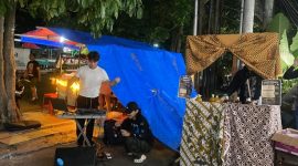 Mahasiswa ilmu komunikasi USM saat memainkan musik DJ. Nampak warung jamu berdampingan dengan angkringan, menambah suasana klasik kekinian.