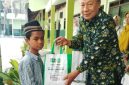 Kepala MTs NU Raudlotus Shibnyan, Abdul Manan, saat memberikan paket bantuan sembako kepada anak kurang mampu.