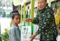 Kepala MTs NU Raudlotus Shibnyan, Abdul Manan, saat memberikan paket bantuan sembako kepada anak kurang mampu.