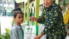 Kepala MTs NU Raudlotus Shibnyan, Abdul Manan, saat memberikan paket bantuan sembako kepada anak kurang mampu.