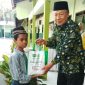 Kepala MTs NU Raudlotus Shibnyan, Abdul Manan, saat memberikan paket bantuan sembako kepada anak kurang mampu.
