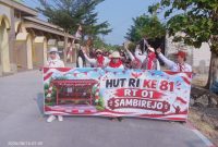 Peserta jalan sehat warga sambirejo RT 01 RW 04, saat melintasi jalan raya disamping Masjid Muttaqin Sambirejo. Minggu (16/8/2026).