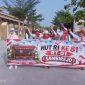 Peserta jalan sehat warga sambirejo RT 01 RW 04, saat melintasi jalan raya disamping Masjid Muttaqin Sambirejo. Minggu (16/8/2026).
