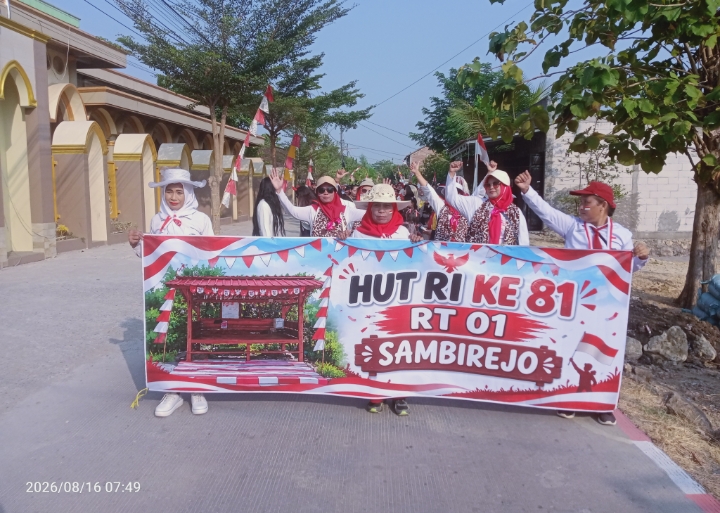 Peserta jalan sehat warga sambirejo RT 01 RW 04, saat melintasi jalan raya disamping Masjid Muttaqin Sambirejo. Minggu (16/8/2026).