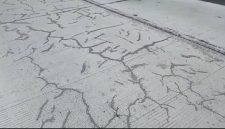 Foto: Kondisi proyek jalan beton nampak retak-retak hitam tambalan aspal.