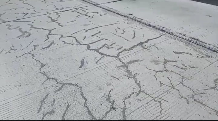 Foto: Kondisi proyek jalan beton nampak retak-retak hitam tambalan aspal.