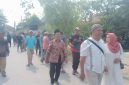 Foto: H. Moh. Asrori, didampingi istri (Nurkhasanah) bersama ratusan warga pendukung, berjalan kaki menuju kantor sekretariat panitia Pilkades, untuk mendaftar bakal calon kades Putatnganten. Senin (12/10/2026).