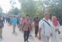 Foto: H. Moh. Asrori, didampingi istri (Nurkhasanah) bersama ratusan warga pendukung, berjalan kaki menuju kantor sekretariat panitia Pilkades, untuk mendaftar bakal calon kades Putatnganten. Senin (12/10/2026).