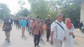 Foto: H. Moh. Asrori, didampingi istri (Nurkhasanah) bersama ratusan warga pendukung, berjalan kaki menuju kantor sekretariat panitia Pilkades, untuk mendaftar bakal calon kades Putatnganten. Senin (12/10/2026).