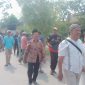 Foto: H. Moh. Asrori, didampingi istri (Nurkhasanah) bersama ratusan warga pendukung, berjalan kaki menuju kantor sekretariat panitia Pilkades, untuk mendaftar bakal calon kades Putatnganten. Senin (12/10/2026).
